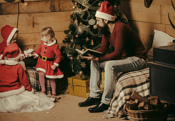 Christmas happy children and father read book. - Zdjęcie, obraz