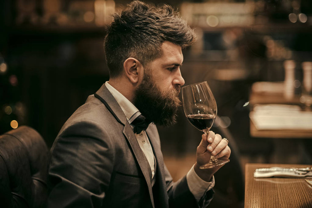 Perfect wine. Businessman with long beard drink in cigar club. bar customer sit in cafe drinking alcohol. Bearded man rest in restaurant with wine glass. Date meeting of hipster awaiting in pub. - Foto, immagini