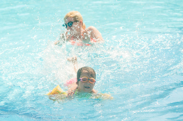 ευτυχισμένο κοριτσάκι με τη μητέρα έχει τη διασκέδαση στην πισίνα στο υδάτινο πάρκο  - Φωτογραφία, εικόνα
