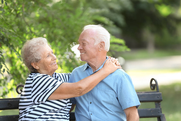 Älteres Ehepaar ruht sich auf Bank im Park aus - Foto, Bild