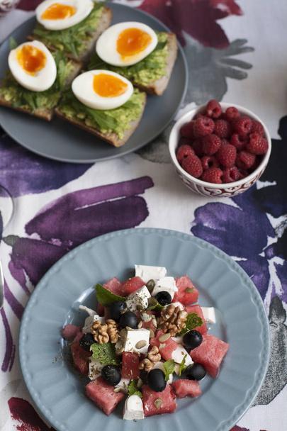 Легкий летний ужин на двоих: салат, вареные яйца, малина на десерт и белое вино
. - Фото, изображение
