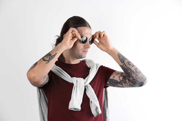 Young man with stylish tattoos on white background - Foto, immagini