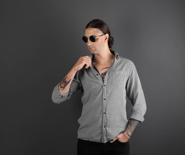 Young man with stylish tattoos on grey background. Space for text - Zdjęcie, obraz