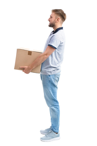 Full length portrait of young man carrying carton box on white background. Posture concept - 写真・画像