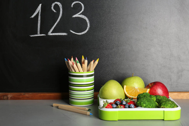 Egészséges táplálkozás, az iskola gyermek ebédet- és levélpapír asztal mellett tábla krétával írt számok - Fotó, kép