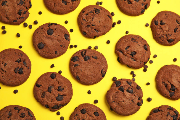 Delicious chocolate chip cookies on color background, flat lay - Foto, Bild