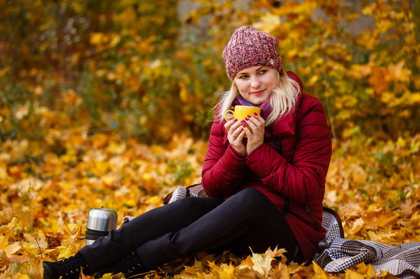 Jeune femme buvant du thé du thermos dans le parc d'automne
 - Photo, image