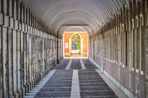 Niesamowite korytarza z kolumnami na boki tworząc tunel. Dom niemowląt w Aranjuez. Ścieżki wokół budynku pałacowego. edytowane zdjęcie. - Zdjęcie, obraz