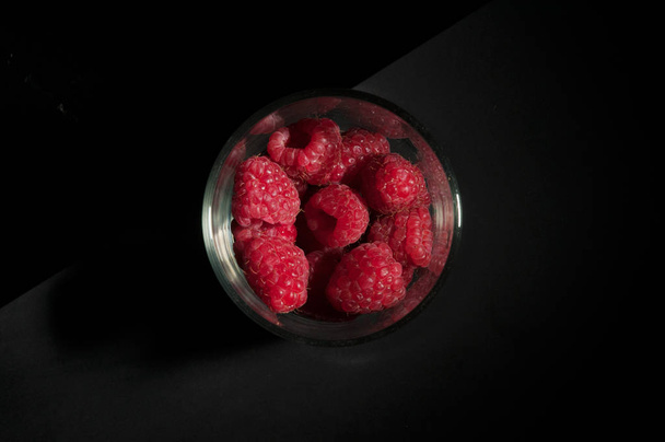 Vista superior de um copo de sobremesa cheio de framboesas vermelhas maduras frescas
 - Foto, Imagem