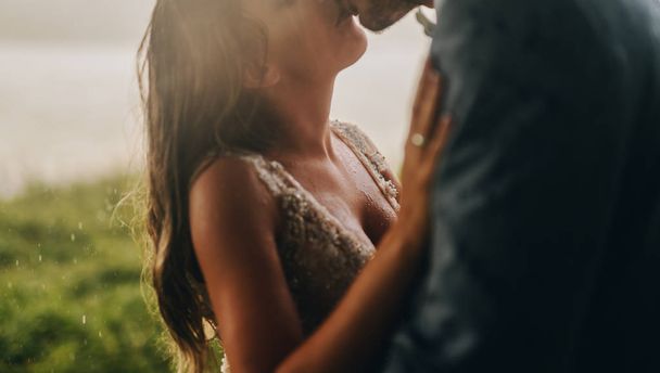 Nahaufnahme eines frisch verheirateten Paares, das draußen steht und sich küsst. Emotionaler Moment am Hochzeitstag. - Foto, Bild