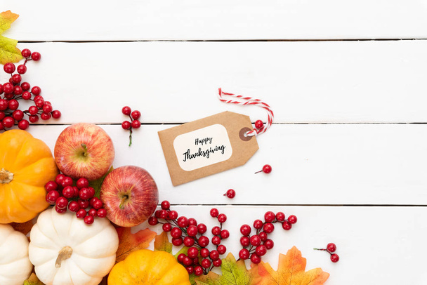 Pohled shora podzimní javorové listy s dýně a červené bobule na bílých dřevěných pozadí. Den díkůvzdání koncept. - Fotografie, Obrázek