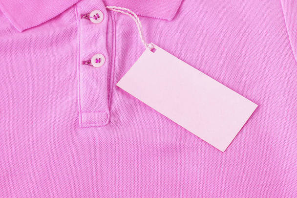 ピンクのシャツの背景の空白のサービスタグ ラベル. - 写真・画像