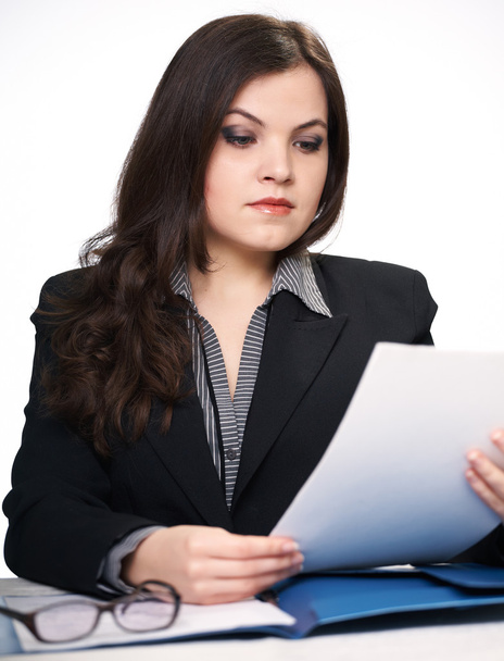 Привлекательная молодая женщина в черном пиджаке сидит за столом. W
 - Фото, изображение