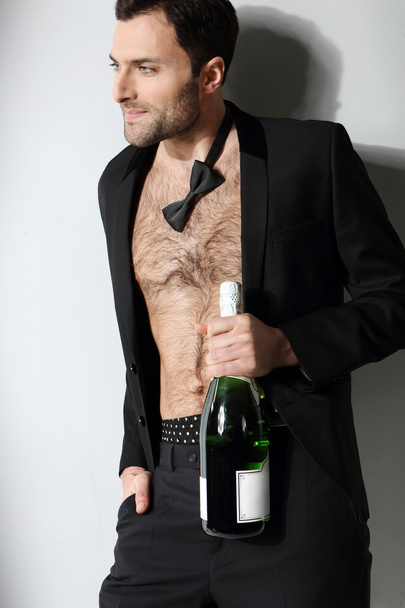 Sexy male model holding champagne bottle - Photo, Image