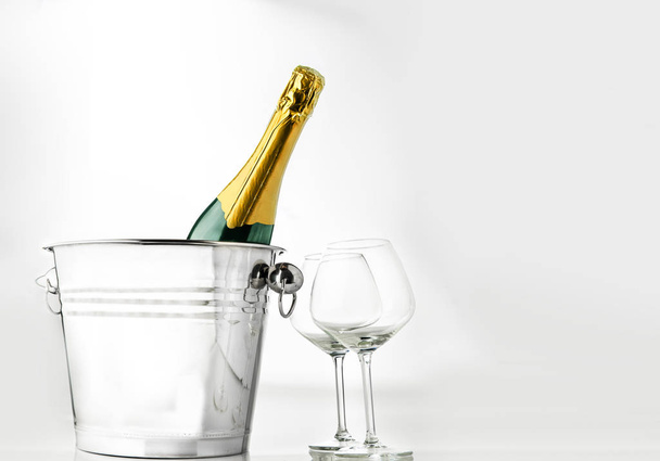 Wine bottle on ice bucket with two wine glasses isolated over white background - Foto, afbeelding