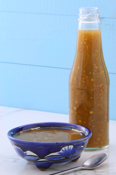 Artisan tomatillo Μεξικάνικη σάλσα σε vintage talavera μπολ, με ένα φρέσκο ζεστό νοστιμιά, vintage carrara μαρμάρινο τραπέζι. - Φωτογραφία, εικόνα