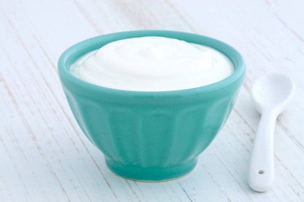 Herkullinen, ravitseva ja terveellinen tavallinen kreikkalainen jogurtti antiikkipuupöydällä
 - Valokuva, kuva