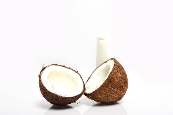Primer plano de coco roto y botella blanca están aislados sobre fondo blanco
 - Foto, imagen