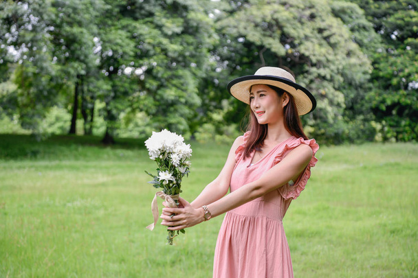 Holiday concept. Beautiful girl is getting flowers. Beautiful girl enjoys the scenery and nature. - Foto, immagini