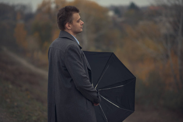 Un hombre con un paraguas en el otoño
 - Foto, Imagen