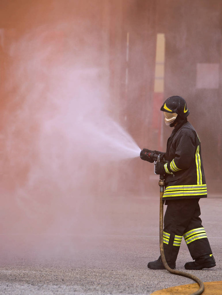 vigile del fuoco utilizza un potente estintore per spegnere un incendio
 - Foto, immagini