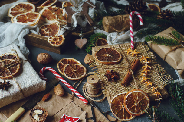 Rami di abete e regali di Natale avvolti in sacco decorato con fette di limone essiccate
 - Foto, immagini