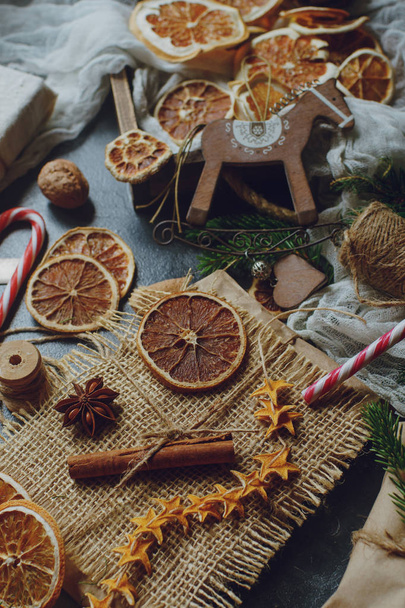 Fir branches and Christmas gifts wrapped in sackcloth decorated with dried lemon slices - Foto, Imagen