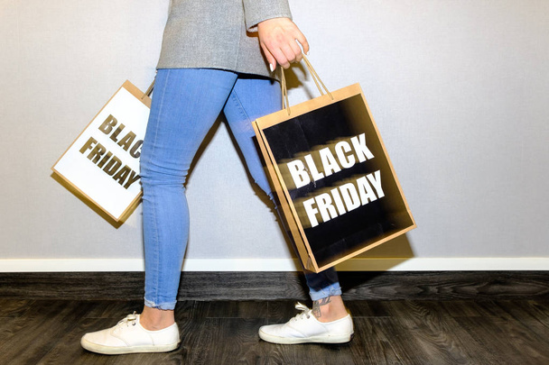 Partial view of a woman holding a black friday paper bag - Foto, Bild