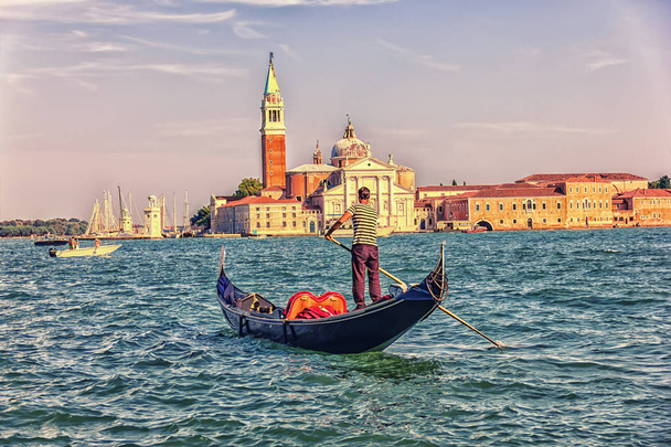 A San Giorgio Maggiore és a gondolier egy gondola, a kilátás a tengerre, Velence, Olaszország - Fotó, kép