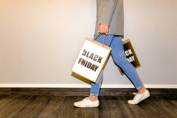 Partial view of a woman holding a black friday paper bag - Foto, imagen