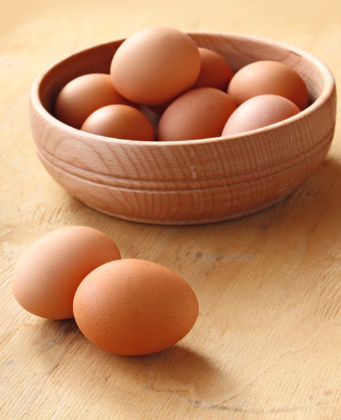 Wooden bowl with the eggs on the table - Photo, Image