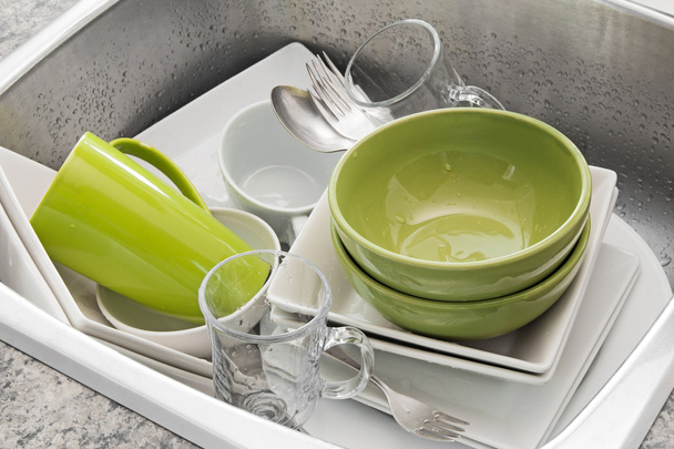 Lavare i piatti nel lavello della cucina
 - Foto, immagini