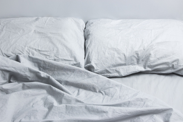 dağınık yatak ile gri yatak örtüsü - Fotoğraf, Görsel