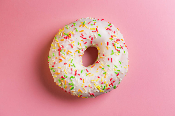 Single round donut on pink background. - 写真・画像