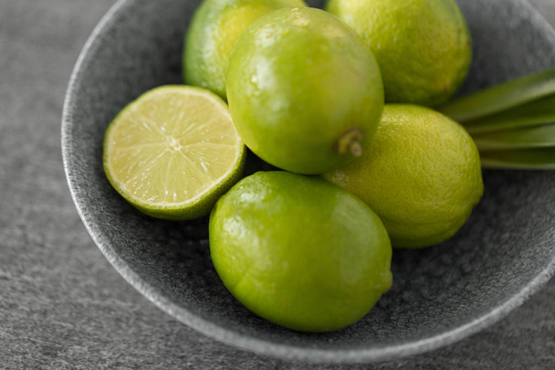 close up of limes in bowl on slate table top - Fotoğraf, Görsel