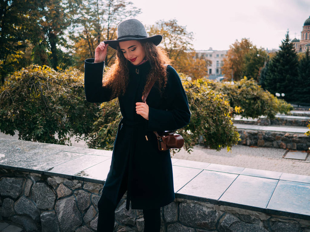 hermosa chica en un abrigo y en un sombrero con una cámara tomando fotos
 - Foto, Imagen