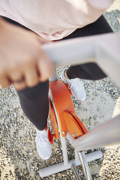 Низька частина жінки, використовуючи тренувальний велосипед
 - Фото, зображення