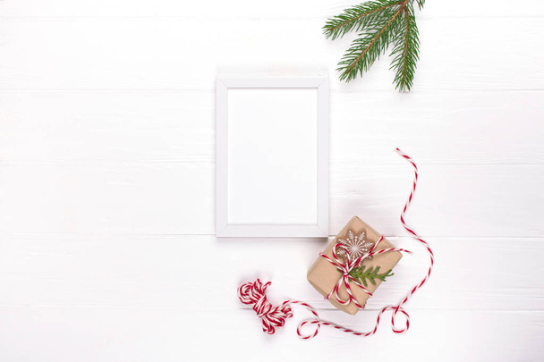 Modèle de Noël avec cadre photo, boîtes-cadeaux écologiques et branches d'arbre. Fête du Nouvel An, concept de vacances. Pose plate, vue du dessus, espace de copie
 - Photo, image