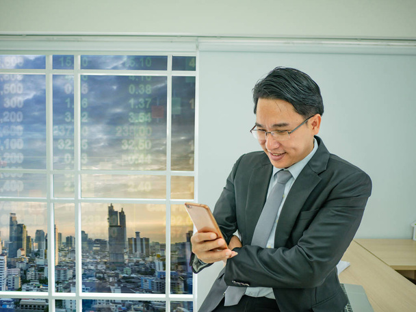 business man check his mobile phone,cityscape with stock number,business concep - 写真・画像
