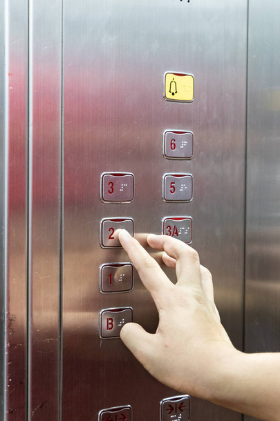Primer plano de braille de lectura de dedos de persona ciega en el panel elevador del ascensor
 - Foto, imagen