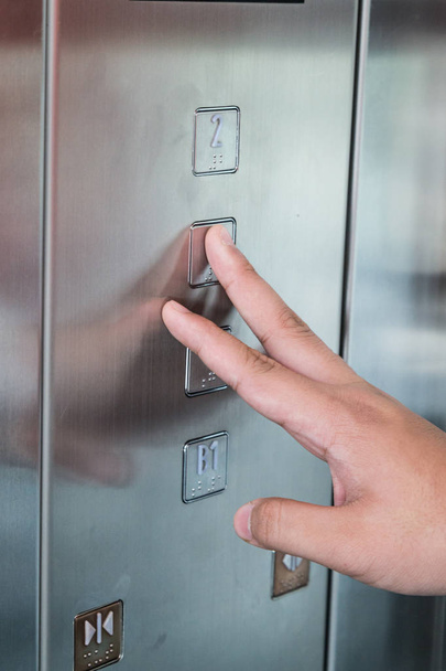 Blind person finger reading braille on elevator lift elevator panel - Valokuva, kuva