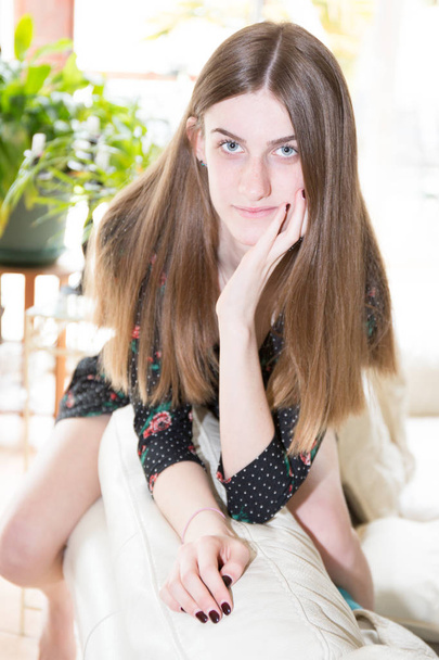 Close up portrait of young happy woman sit on sofa couch on home background - Foto, afbeelding