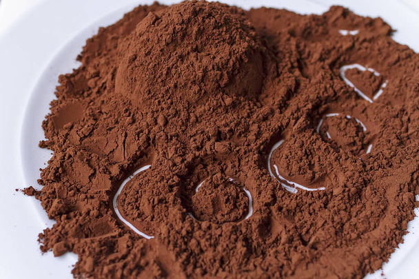 Cacao puro in polvere in un piatto con una parola scritta sopra
 - Foto, immagini