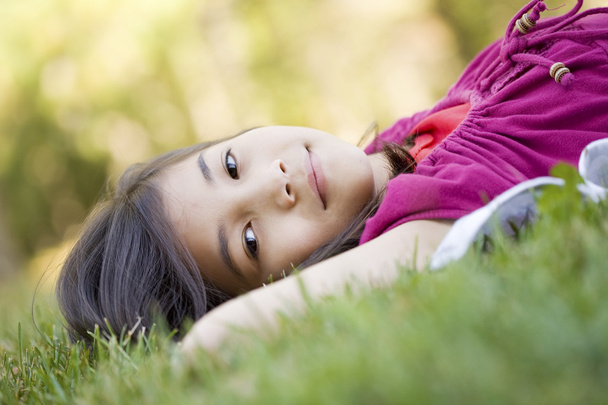 Little girl lying on grass - Fotó, kép