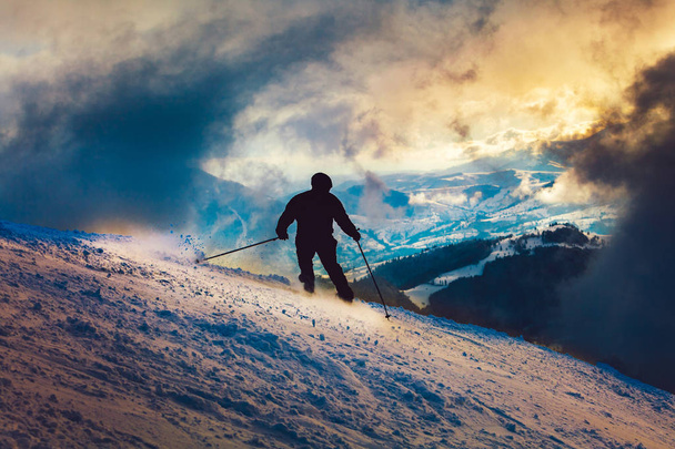 Skier silhouette sunset ride in the mountains - Foto, imagen