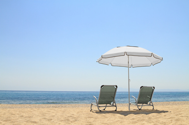 parasole i leżaki krzesła na pięknej plaży - Zdjęcie, obraz