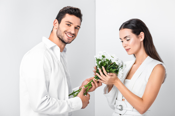 close up of adult woman gently holding bouquet while happy man smiling - Photo, image