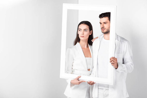 adult couple holding white frame together - Zdjęcie, obraz