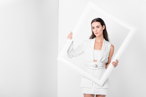 beautiful woman in total white holding white frame - Foto, afbeelding