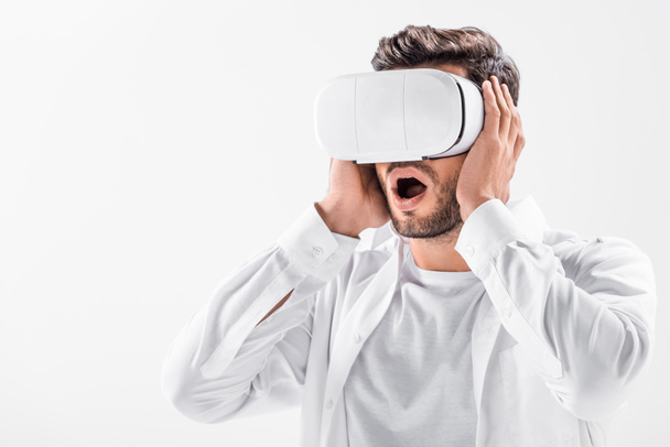 close up of scared adult man in total white wearing virtual reality headset isolated on white - Zdjęcie, obraz